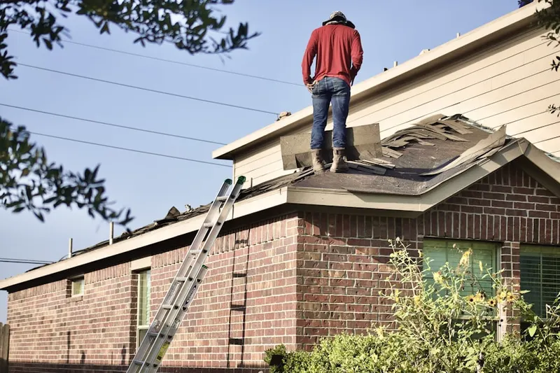 Professional roofer working on a residential roof in West Dundee